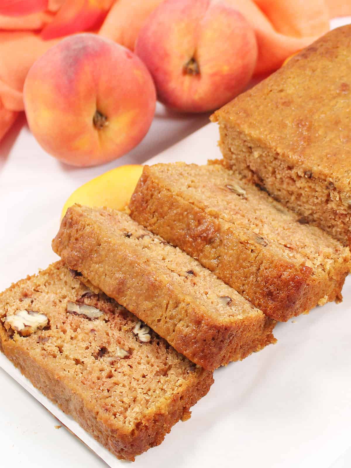 Sliced peach quick bread on parchment.