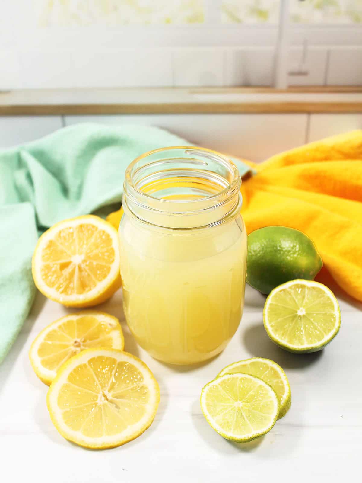 Sweet and sour cocktail mix in mason jar with fruit.