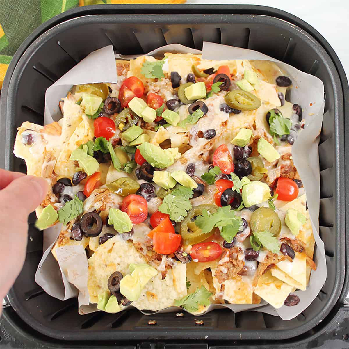 Grabbing a hot nacho chip from the air fryer.