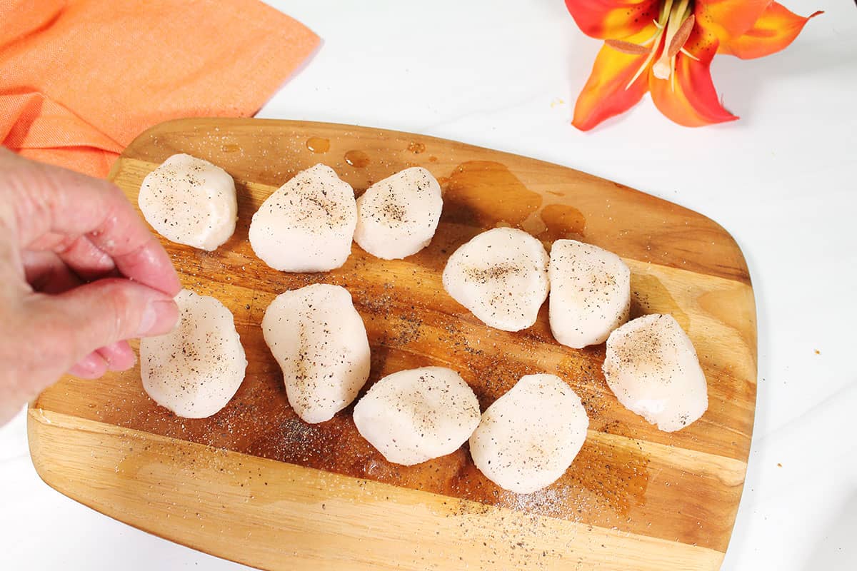Seasoning scallops.