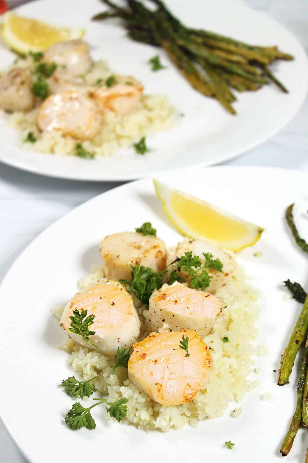 Two plated dinners of air fried scallops with asparagus.