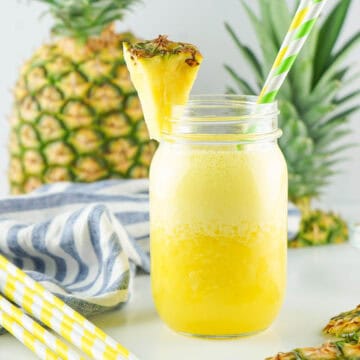Single mason jar filled with pineapple agua fresca by fresh pineapple.
