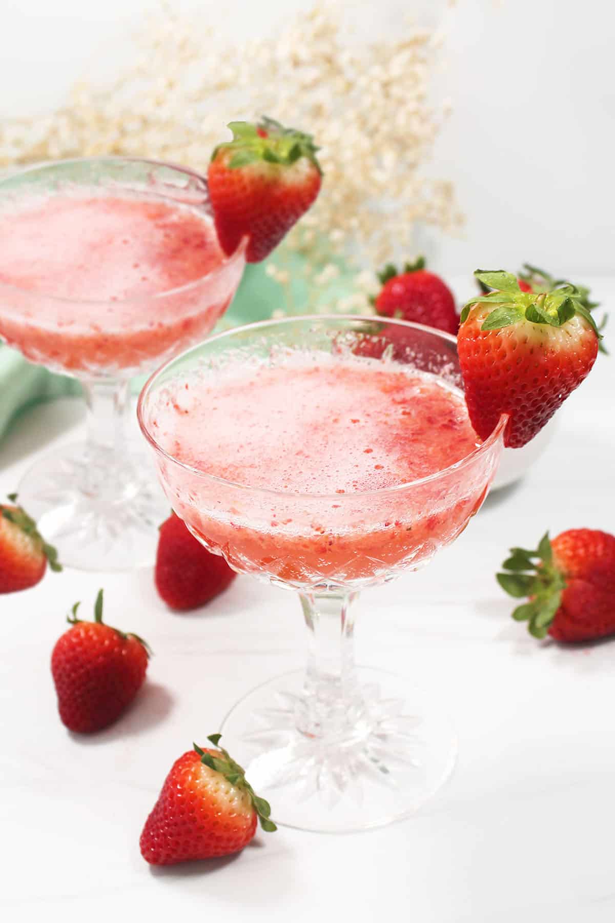 Two Strawberry Bellinis with strawberry garnish.