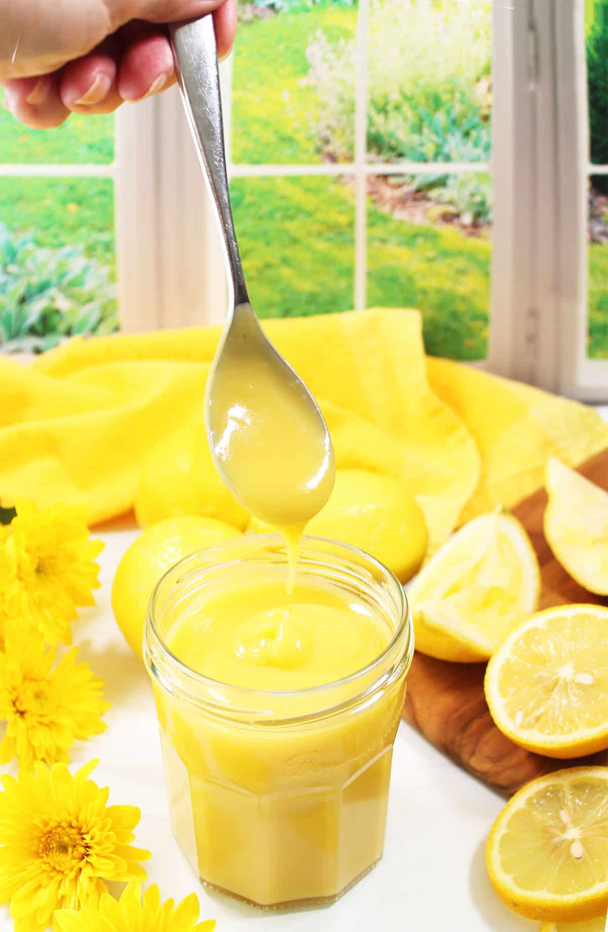 Smooth and creamy  lemon curd dripping off spoon.