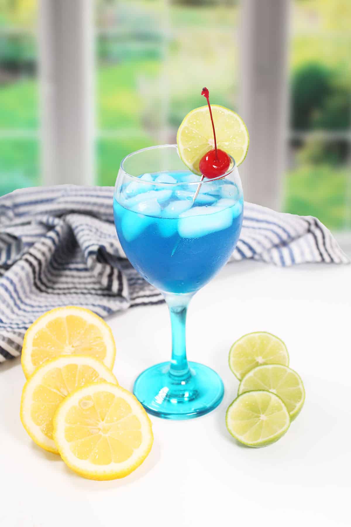 Blue Smurf Cocktail with lemons and limes.