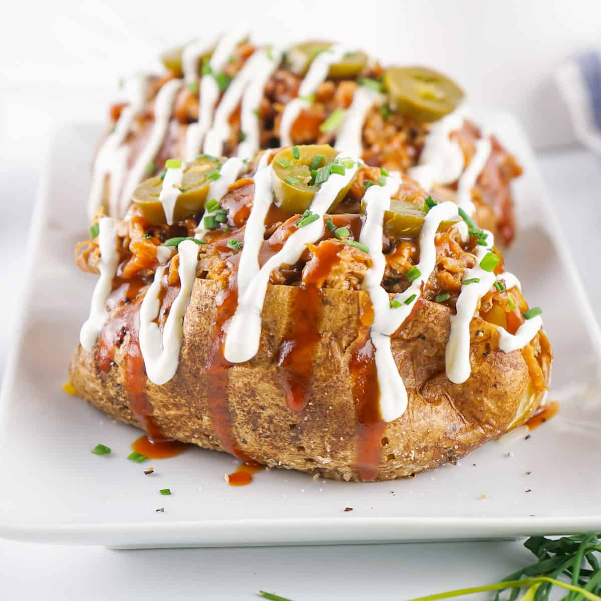 Pulled pork baked potatoes on platter with all the fixings.