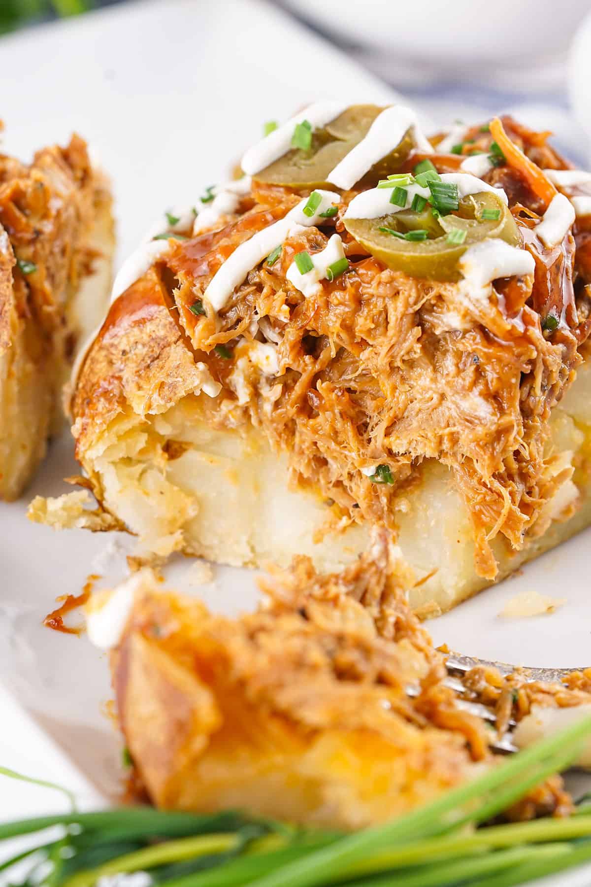 Stuffed baked potato serving with forkful.