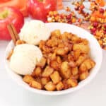 Bowl of air fryer apples with ice cream and apples in back.