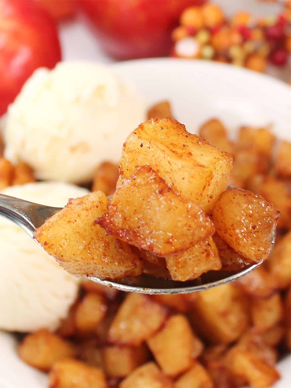 Closeup of spoonful of air fried cinnamon apples.