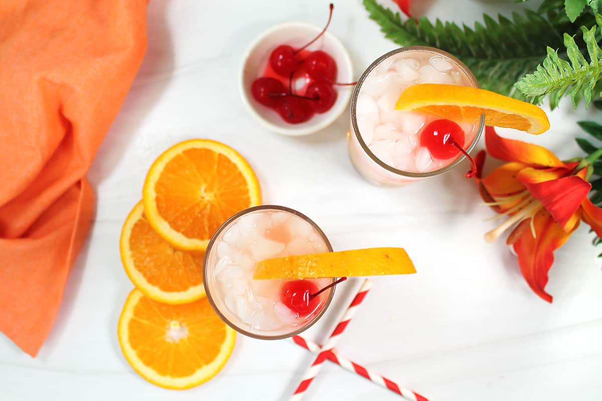 Overhead of amaretto cocktail with oranges and cherries.