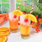 Two Italian Sunset Cocktails with garnishes and straws.