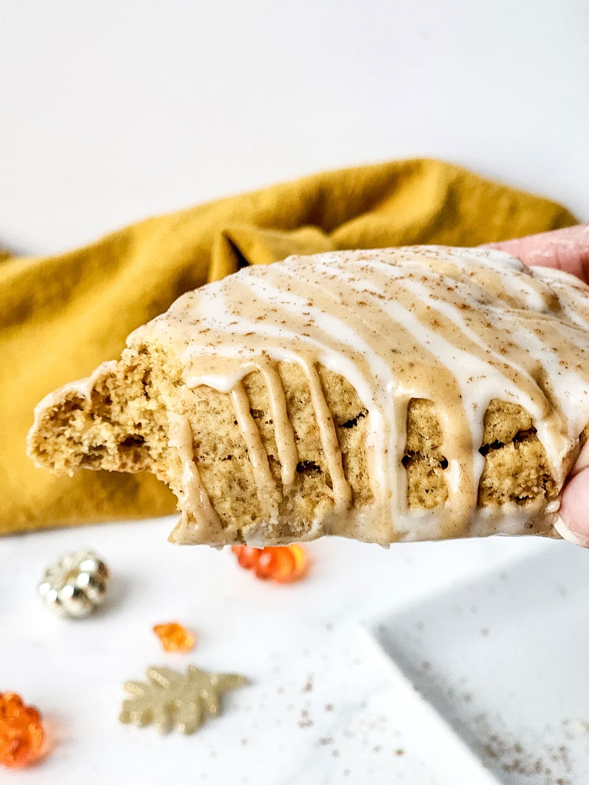 Holding copycat Starbuck pumpkin scone with bite out.