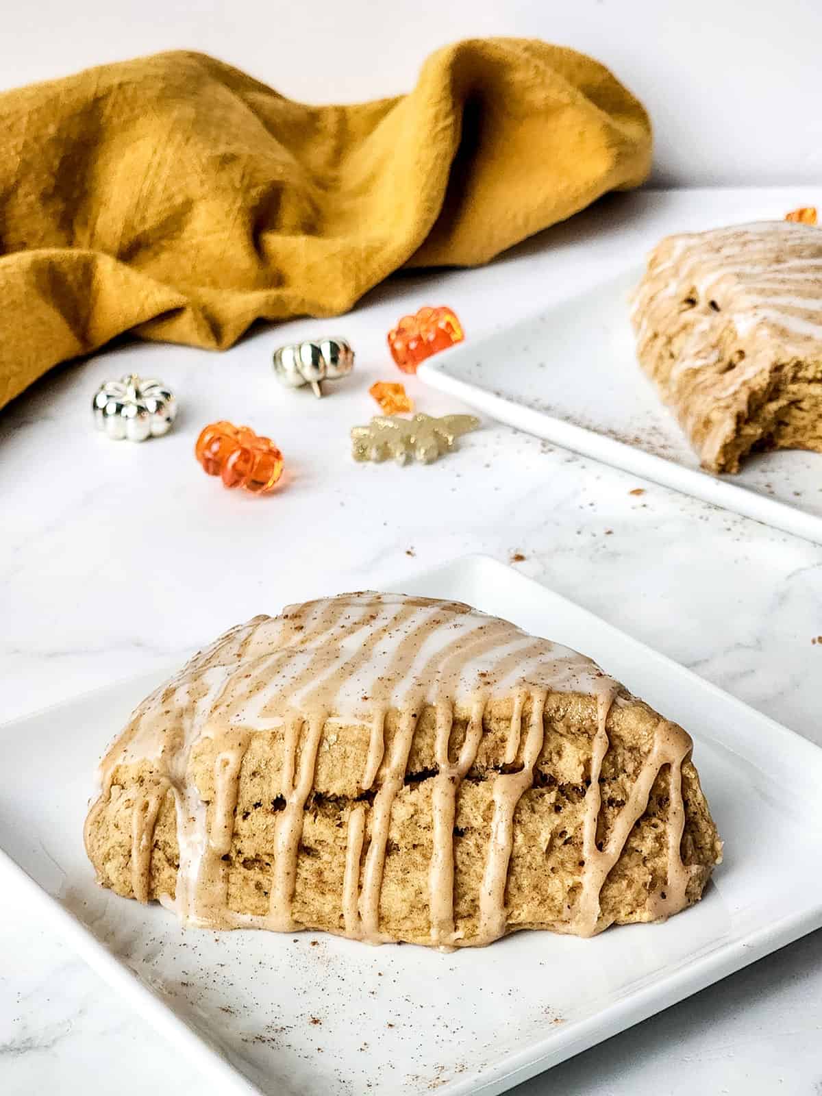 Plated Pumpkin Spice Scone with pumpkin glaze drizzled over top.