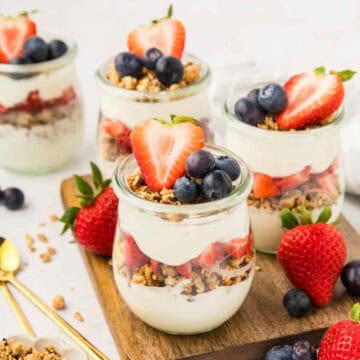 4 Yogurt Parfaits topped with blueberries and strawberries.