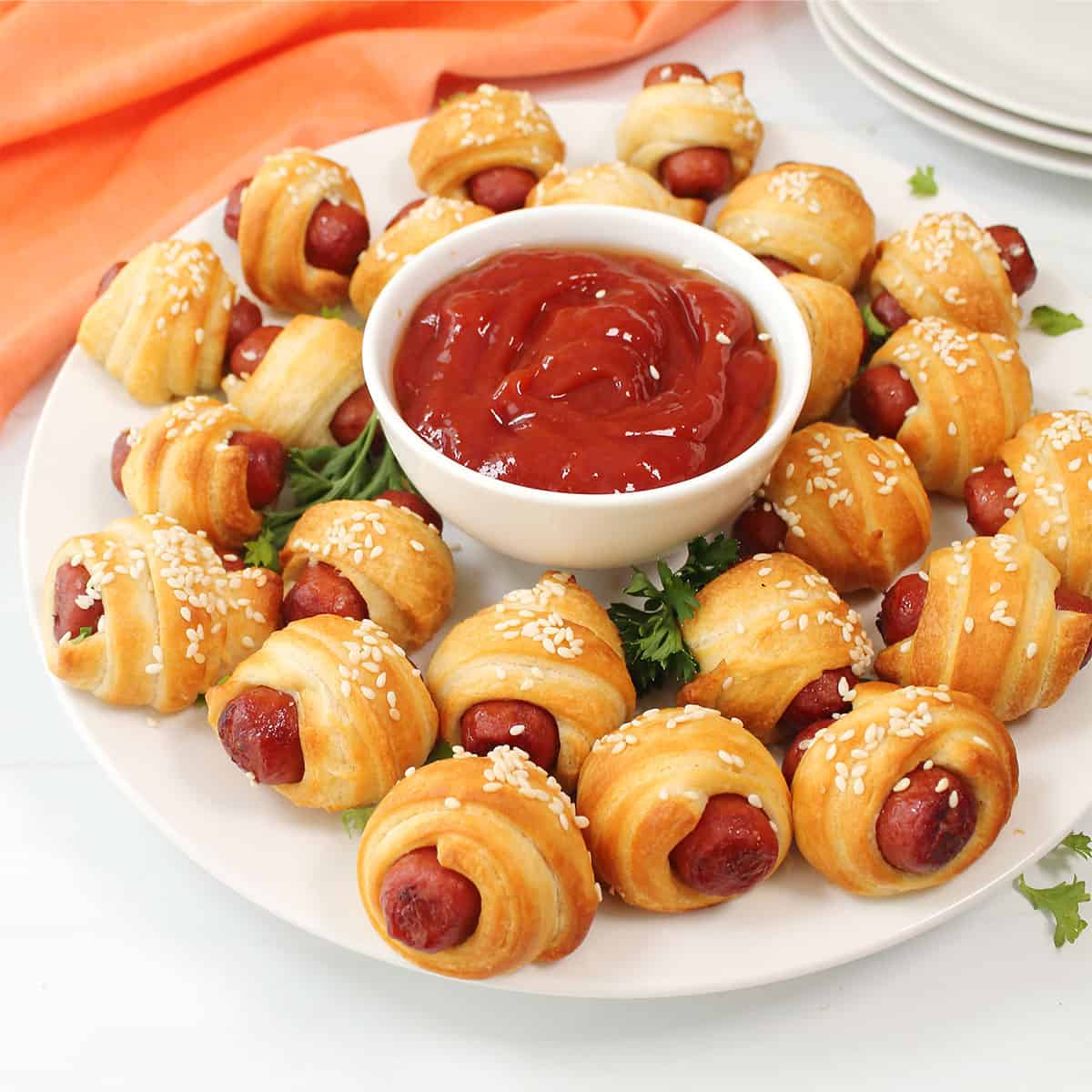 Air Fryer Pigs in a Blanket on white plate with parsley garnish and ketchup.