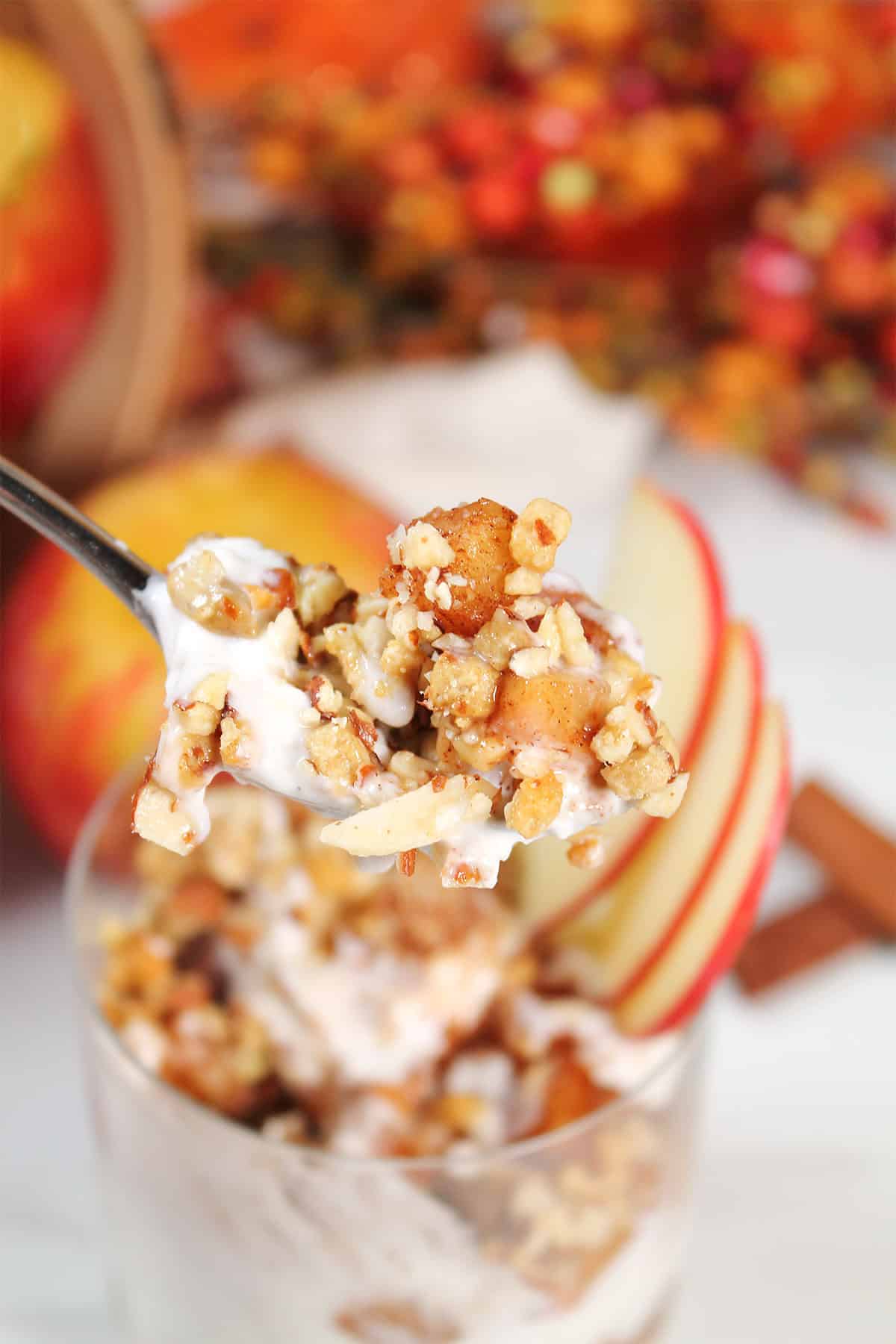 Spoonful of apple pie parfait over glass.