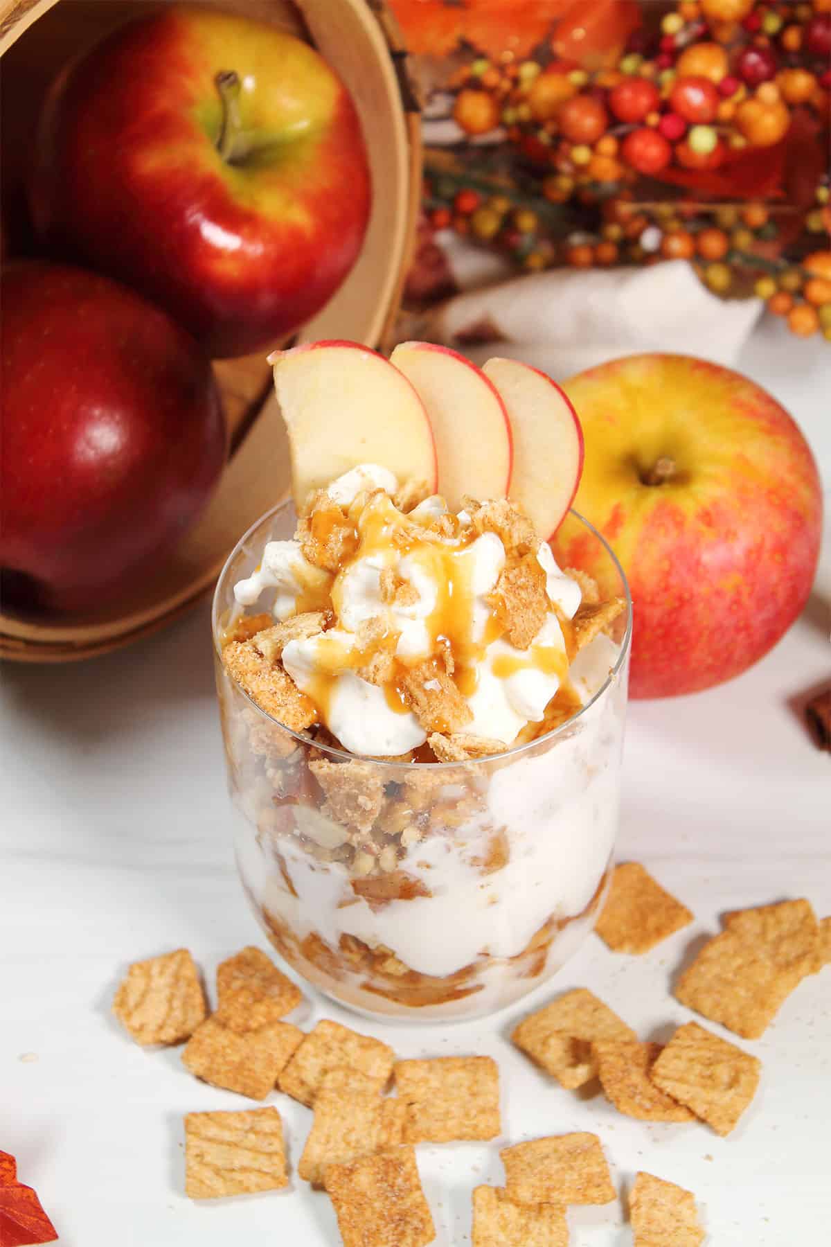 Apple Parfait dessert style in glass with whipped cream and caramel drizzle.