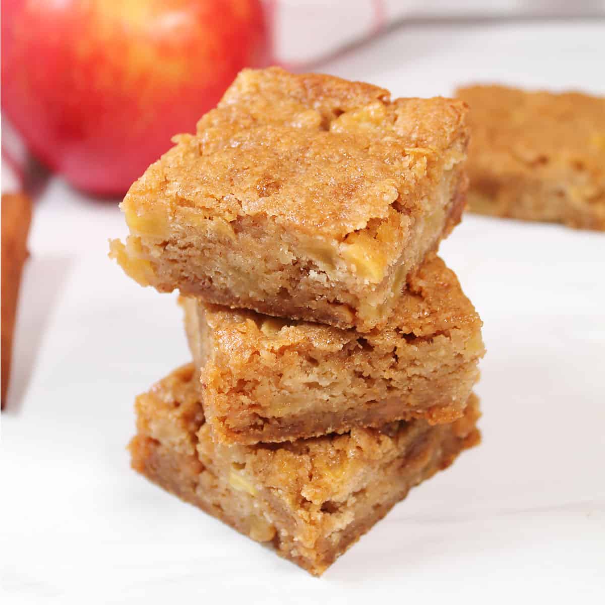 Stack of 3 cinnamon apple blondies on table.
