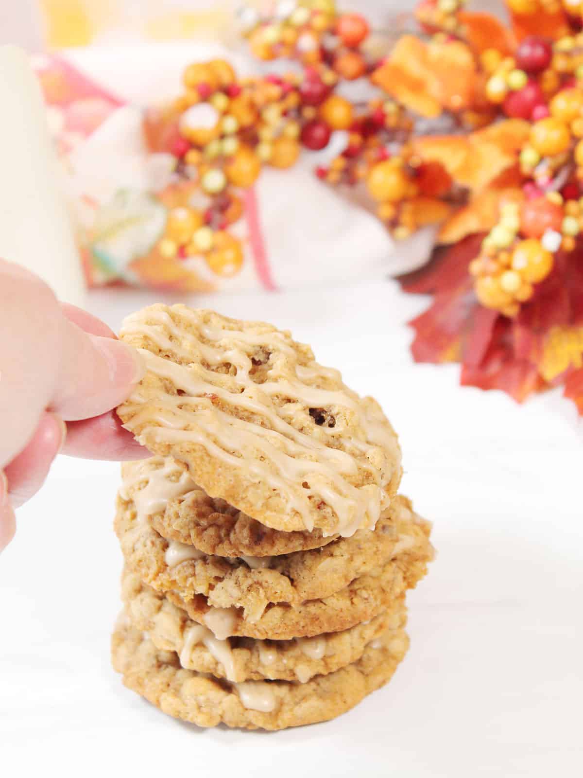 Lifting Maple Oatmeal Cookie off stack of cookies.