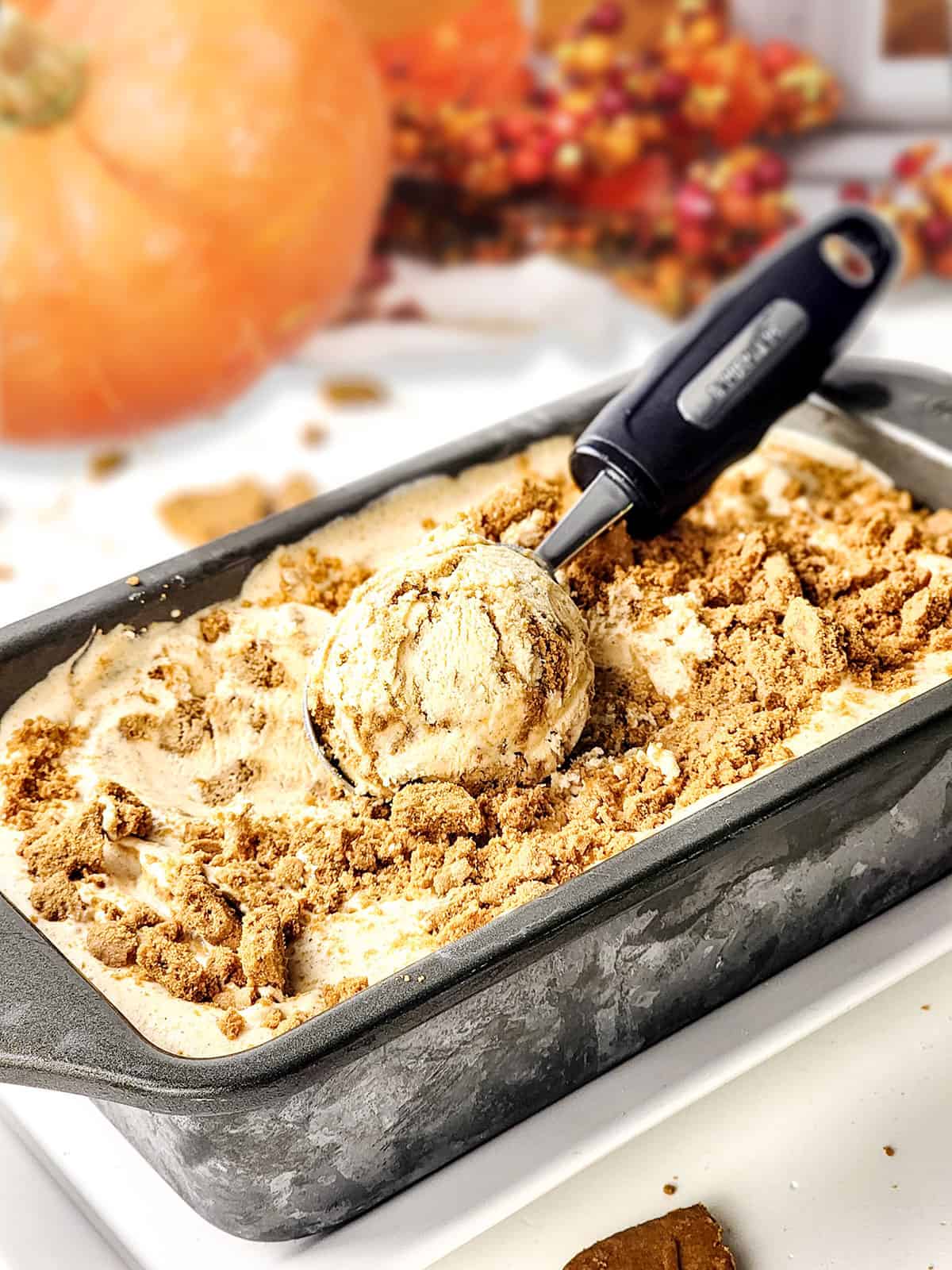 Pumpkin Pie Ice Cream in loaf pan with scoop of ice cream on top.