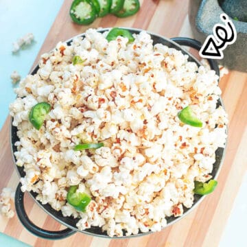 Easy jalapeno popcorn in a bowl with slices of jalapeno.