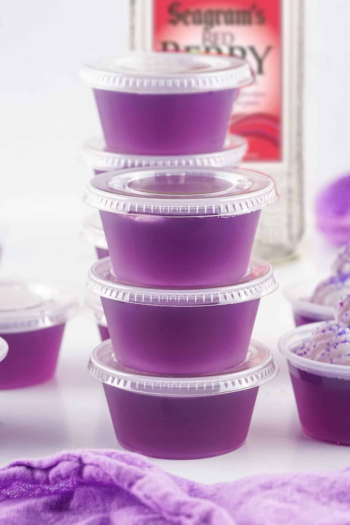 Sealed jello shots in front of berry vodka.