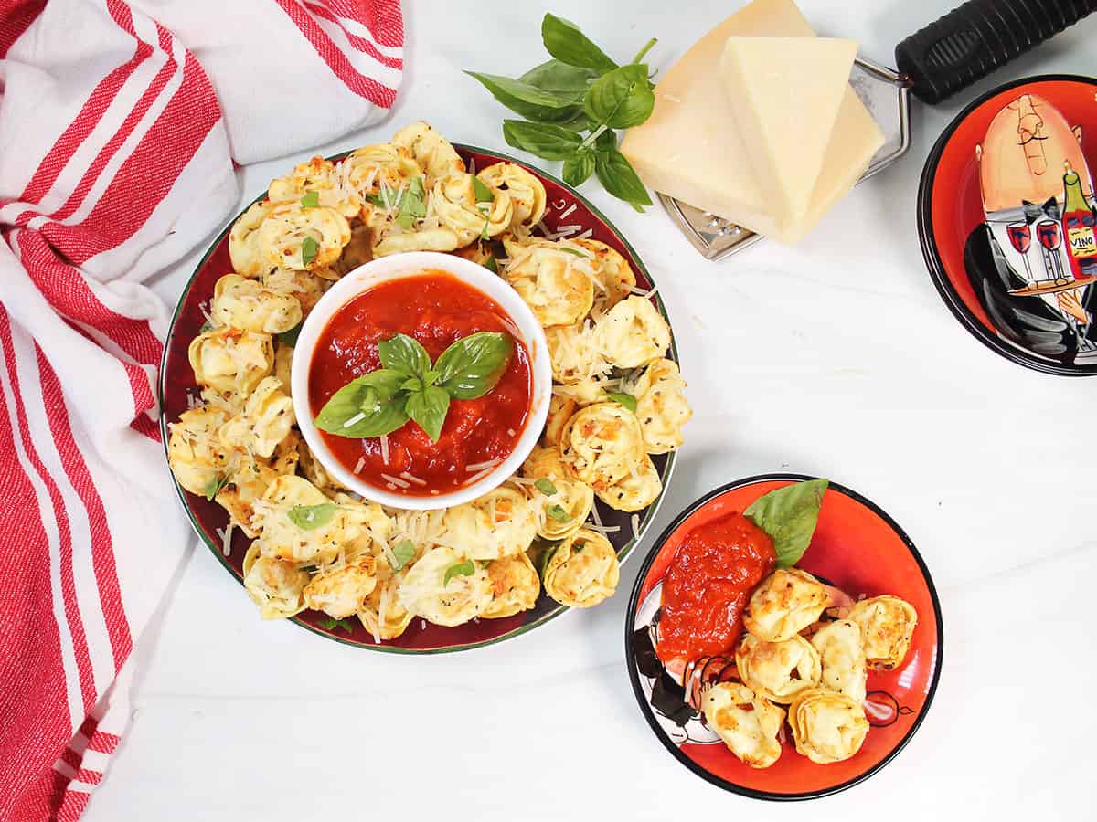 Platter of air fried tortellini with small serving plate.
