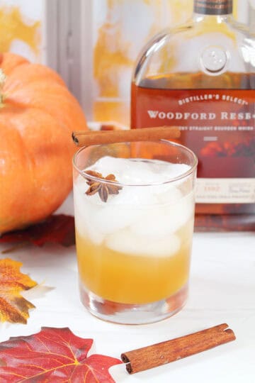 Pumpkin Bourbon Smash in highball glass with cinnamon stick.