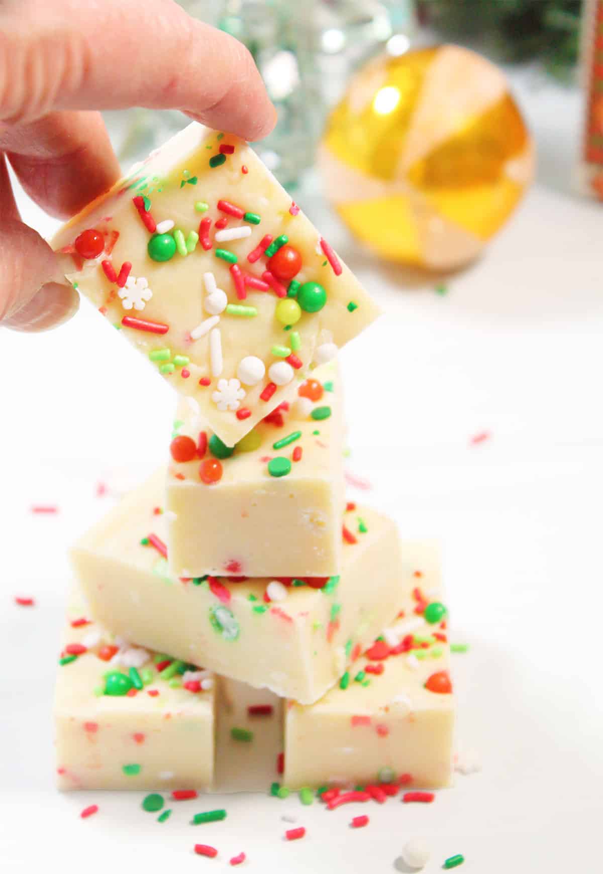 Lifting a piece of sugar cookie fudge from stack.