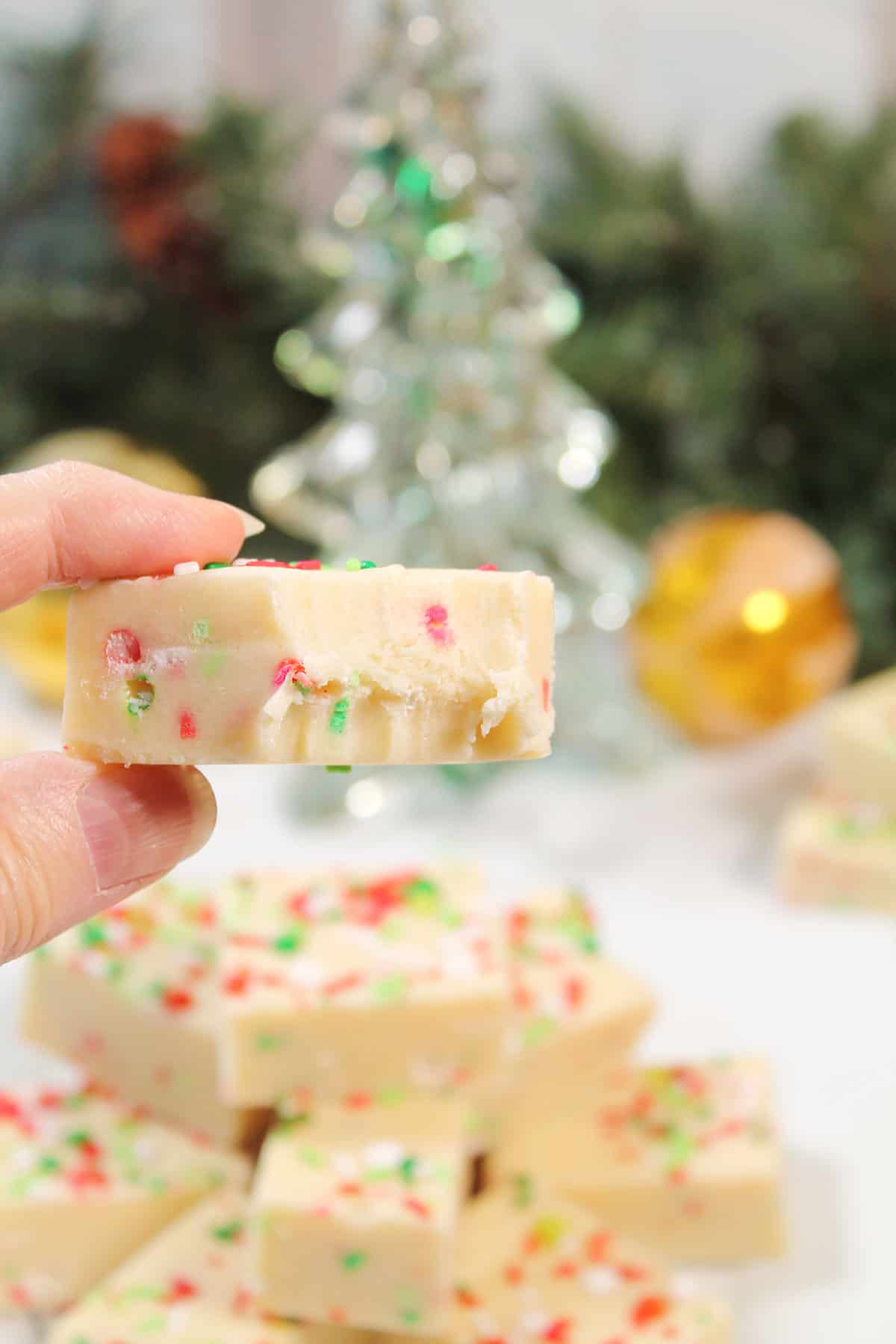 Holding white chocolate sugar cookie fudge with bite out of it.