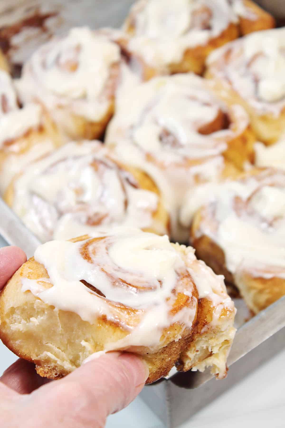 Grabbing a roll from the pan while they're still warm.