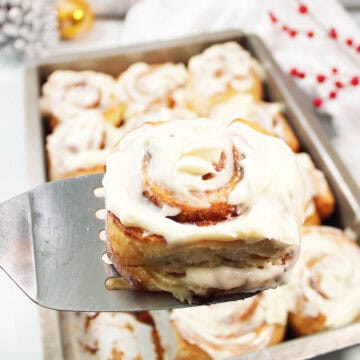 Lifting out Gingerbread Cinnamon Roll from baking pan.
