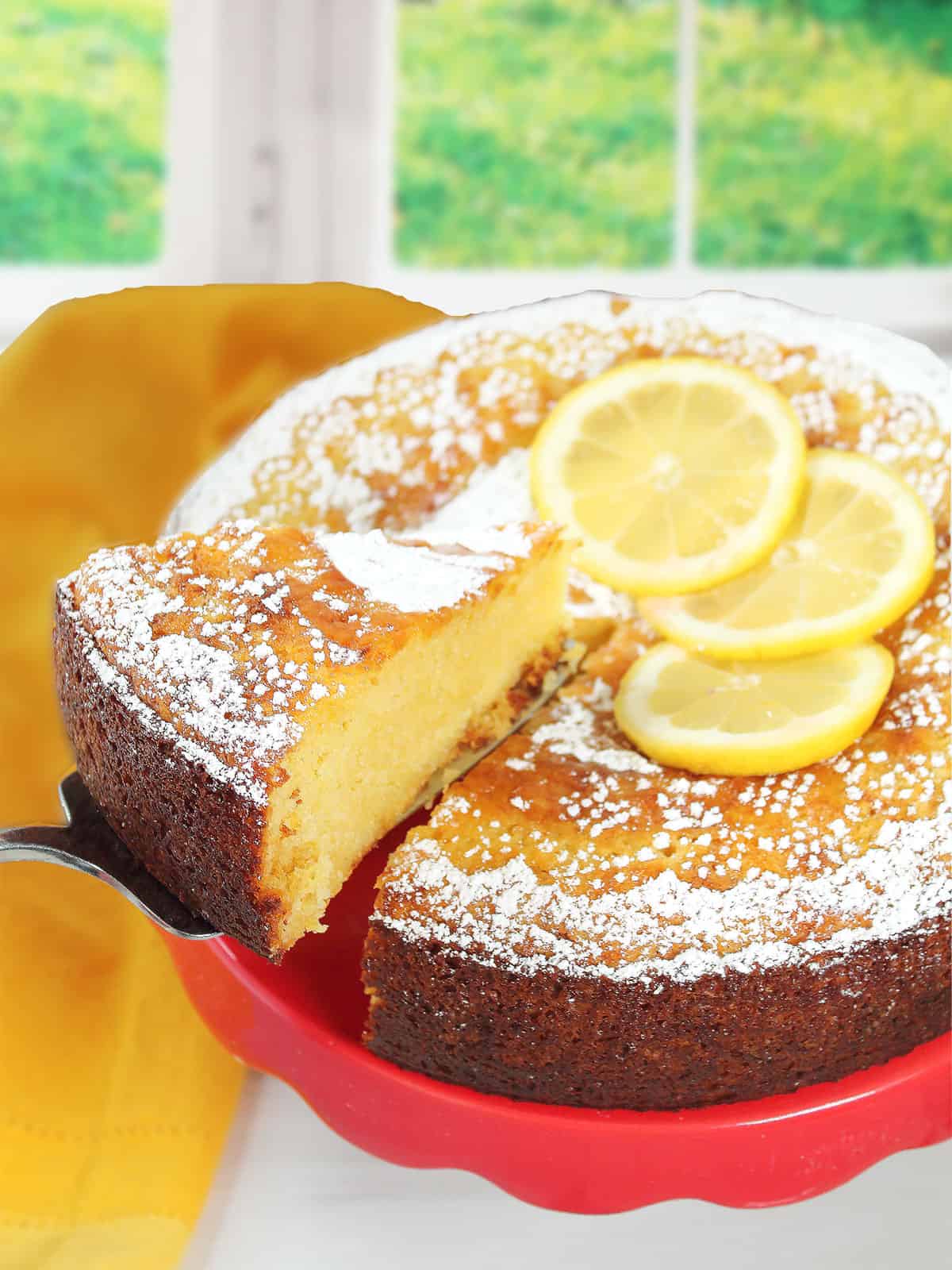 Lifting a slice of Italian lemon ricotta cake from the finished cake.
