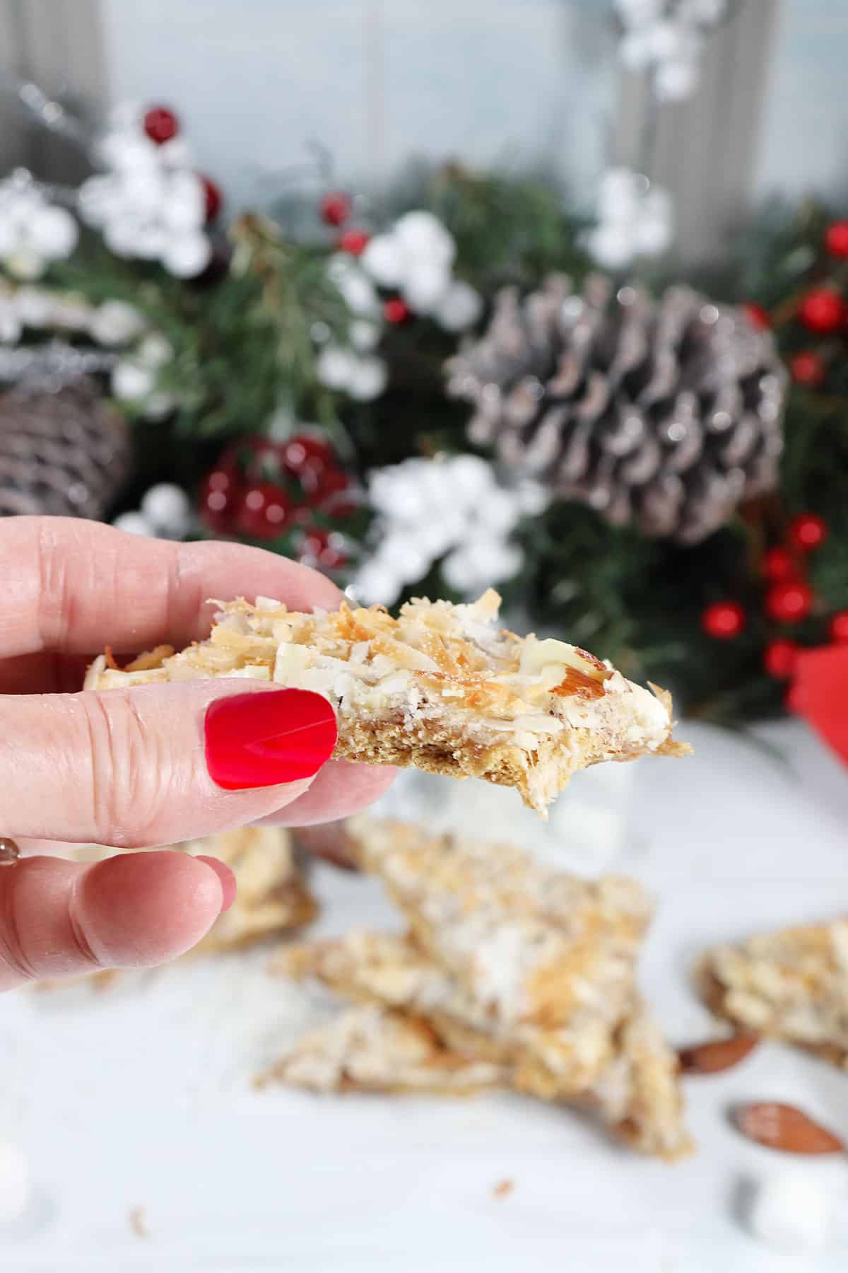 Holding a caramel heavenlies with bite out.