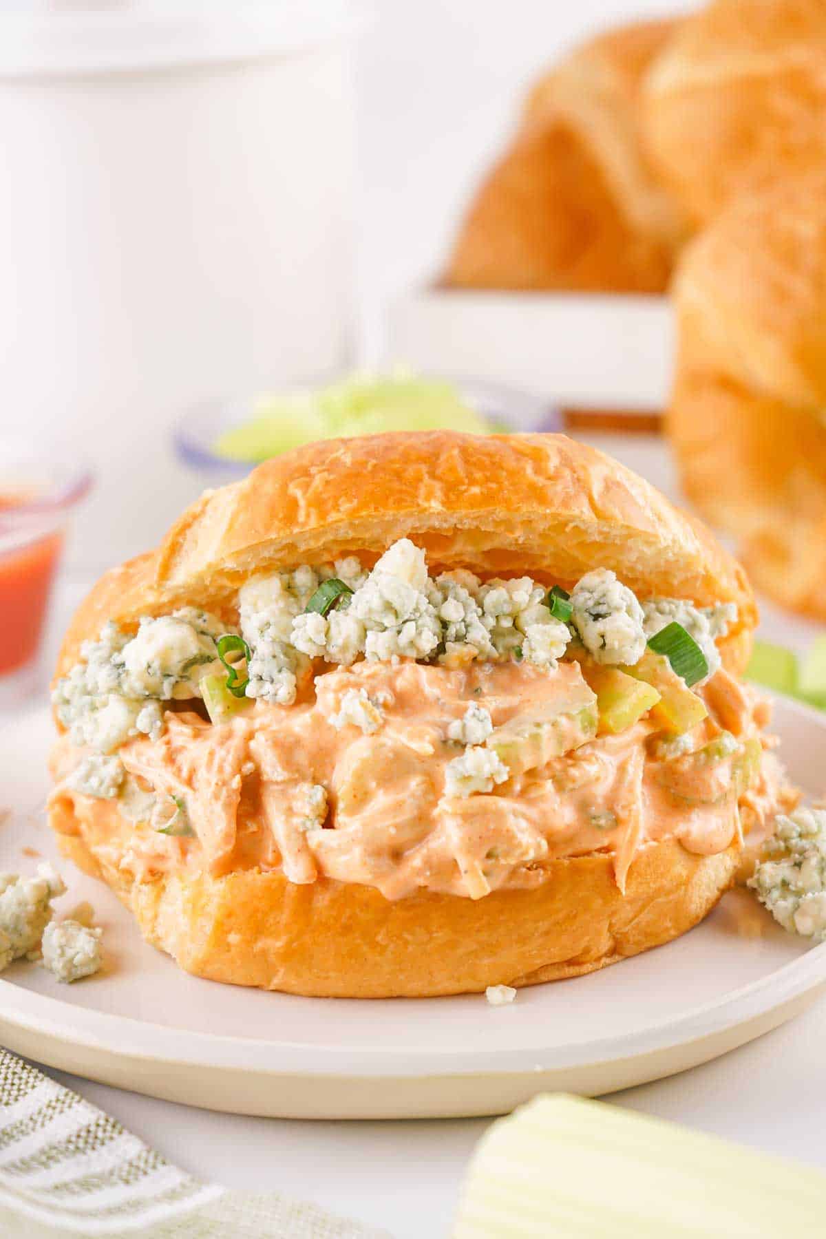 Buffalo Chicken Salad on croissant with blue cheese garnish.