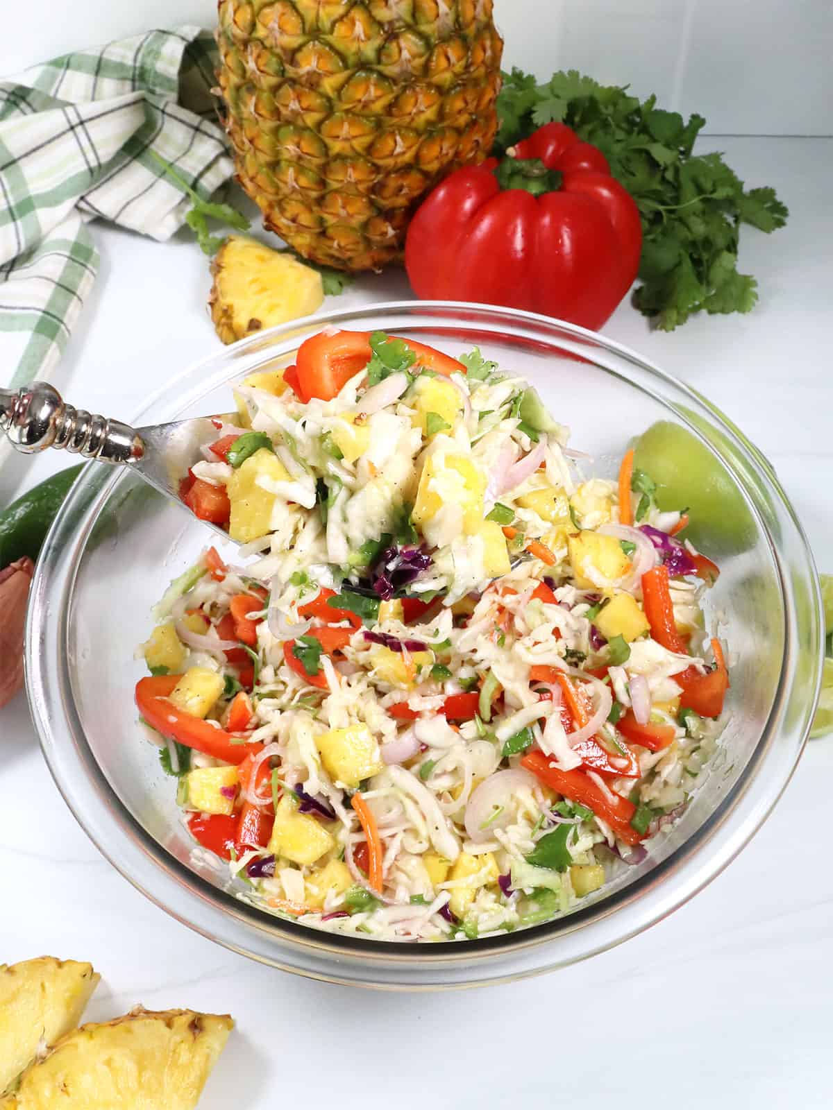 Spoonful of Jalapeno Pineapple Coleslaw over bowl.