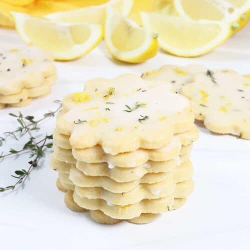Lemon Thyme Shortbread Cookies stacked with lemons.
