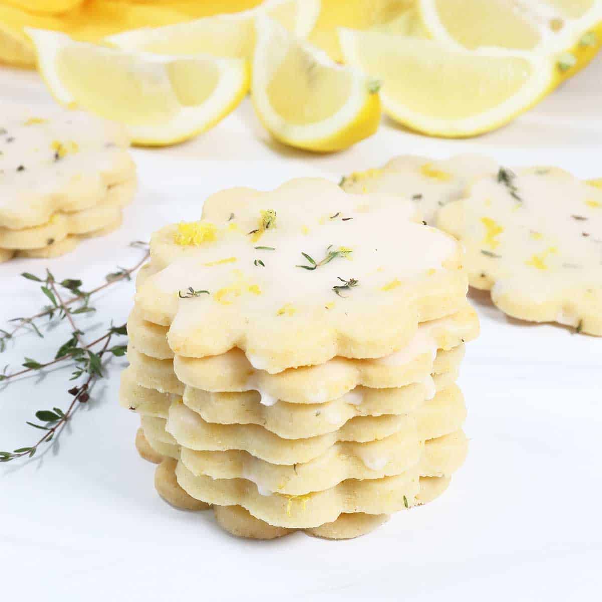 Lemon Thyme Shortbread Cookies stacked with lemons.