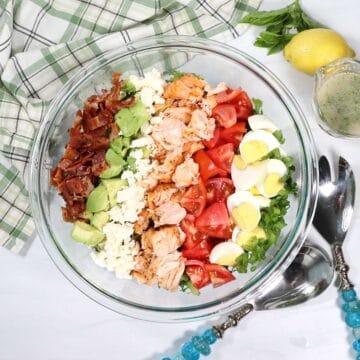 Grilled Salmon Cobb Salad arranged in rows on top of greens.