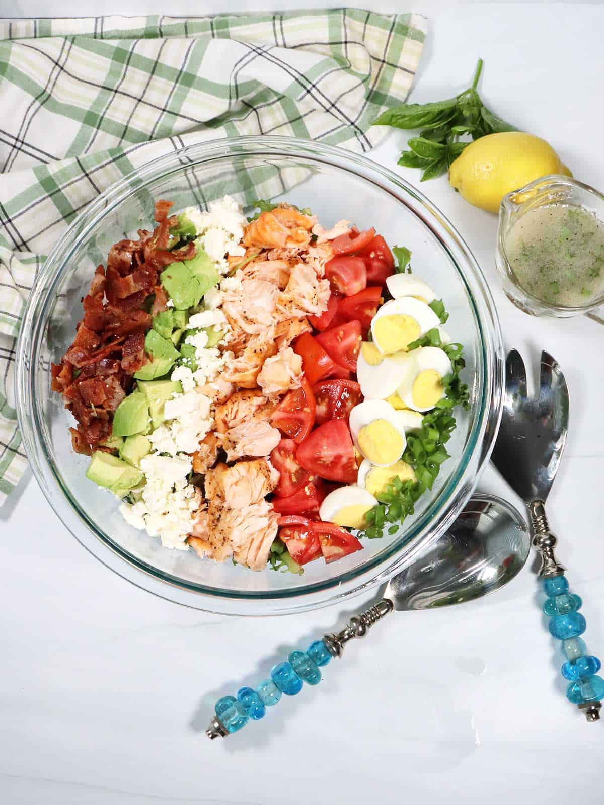 Prep salad by making rows of ingredients on top of greens.